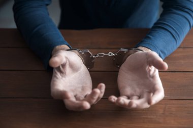 Ahşap sırtta kelepçeli bir adam.