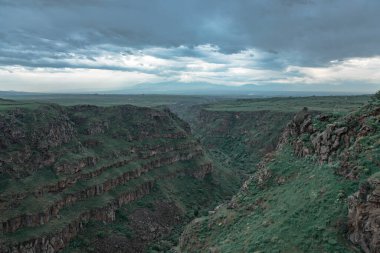 Yeşil çimen kayaları ya da karanlık sırtın altındaki dağ