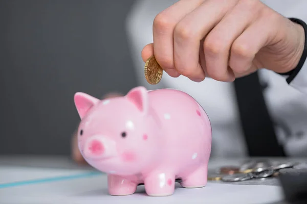 stock image business man holding coin with piggy ban