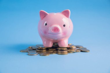 Mavi masanın üzerinde bozuk paralar olan kumbara.