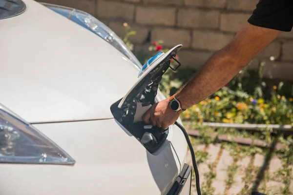 Man charges an electric car at the charging statio