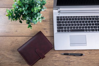 Dizüstü bilgisayarı ve not defteri olan bir ofis masası.