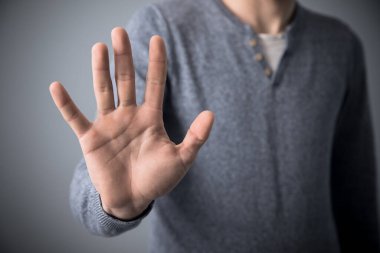 Gri sırtüstü dur işareti yapan adam