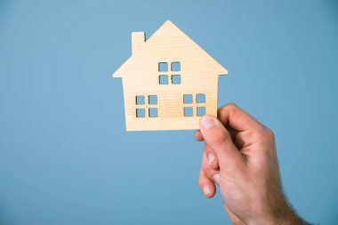 Genç adam ahşap ev modu tutuyor.