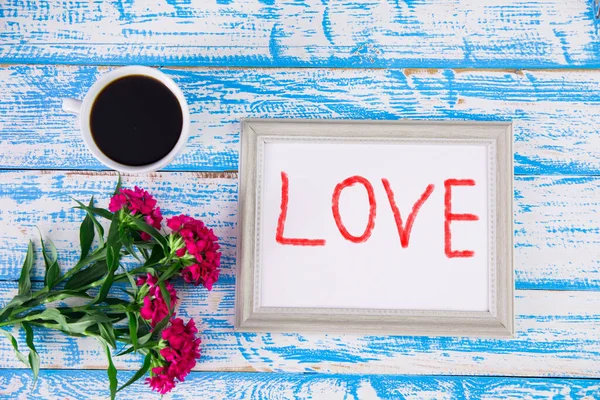 Çerçevede aşk, kahve ve çiçekle mavi bakgroun 'da