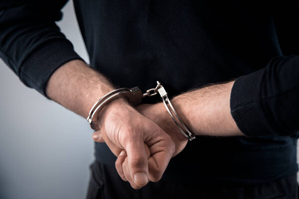 man hand handcuffs in bac