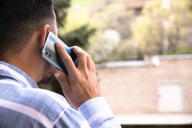 Genç adam akıllı telefonlardan konuşuyor.