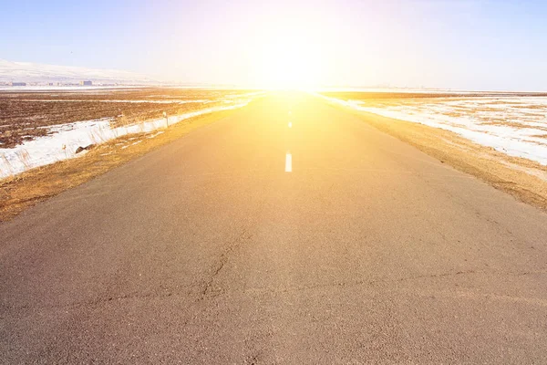 Güneşin Altında Asfalt Yolu Olan Karlı Bir Yer — Stok fotoğraf