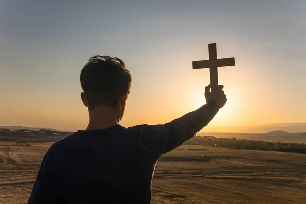 Gün Batımında Haç Tutan Genç Adam — Stok fotoğraf