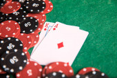 Karty a žetony pro poker na zeleném stole