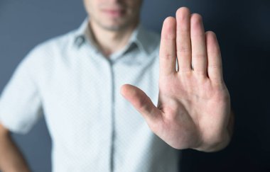 İş adamı, Grey Backgroun 'da dur işareti yapıyor.