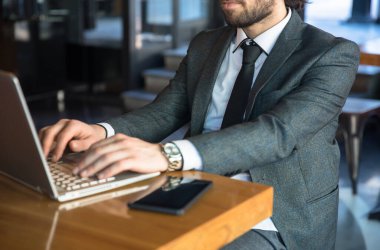 Kafedeki bilgisayarda çalışan bir iş adamı.