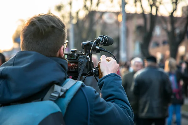 man video operator shoots video in stree