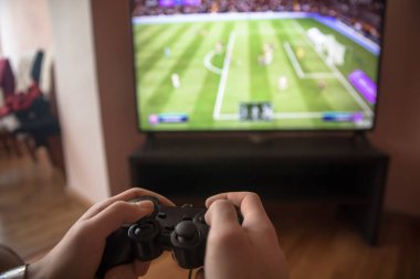 Evde bir video oyunu oynarken Joystick Kontrolörü Tutmak