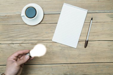 Elinde ampul tutan adam (fikir, bir fincan kahve, not defteri))