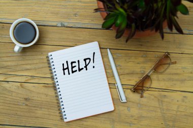 Ahşap bir arka planda bir defter, bardak ve kahve.