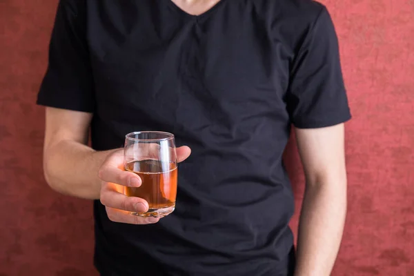 Man with glass of whiskey indoors. Alcohol dependence concep