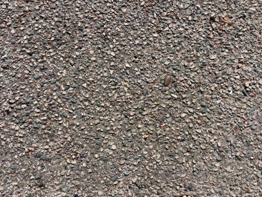 Çok renkli çakıl taşları ve çakıl taşları olan sert kaldırımlara yakın çekim. Şehir dokusu ve inşaat ayrıntıları.