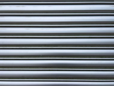 Yatay kirişli gümüş metal kapaklı yakın çekim. Tasarım, güvenlik ve mimari temalar için sanayi dokusu.