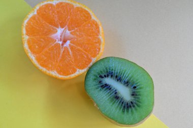 Çiğ taze portakal dilimleri ve masada kivi, yakın görüş.  