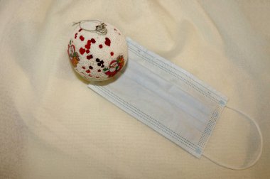 Hafif arka planda yüz maskesi olan noel takısı, koronavirüs konsepti.