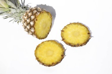 Yarısı taze olgun ananas dilimleri ile beyaz arka planda, sağlıklı gıda konsepti, yakın görüş 