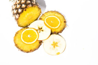 Taze olgun ananas ve elma dilimleri, beyaz arka planda portakal, sağlıklı gıda konsepti, yakın görüş. 