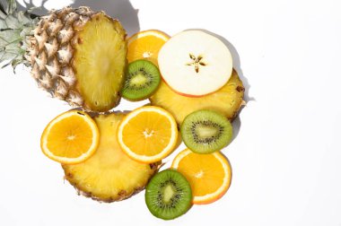 Beyaz arka planda taze olgun ananas ve elma dilimleri, portakal ve kivi, sağlıklı gıda konsepti, yakın görüş 