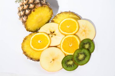 Beyaz arka planda taze olgun ananas ve elma dilimleri, portakal ve kivi, sağlıklı gıda konsepti, yakın görüş 