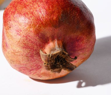 Beyaz zemin üzerinde taze kırmızı nar, yakın görüş, sağlıklı besin konsepti 