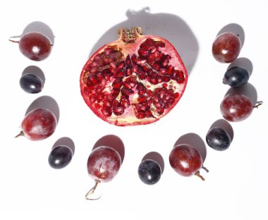 Beyaz arka planda üzümlü taze kırmızı nar, yakın görüş, sağlıklı besin konsepti 