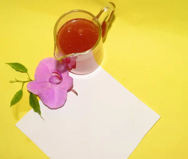 Красива Квітка Орхідеї Склянкою Сиропу Білою Порожньою Карткою Світлому Фоні — стокове фото