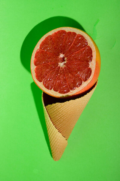 fresh ripe grapefruit and ice-cream waffle cone, close view 