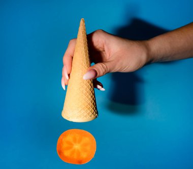 Domates yakalamaya çalışan dondurmalı waffle külahıyla el, yakın görüş. 