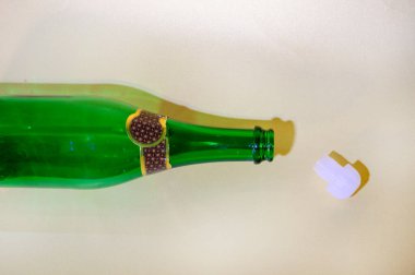 Boş şampanya şişesi ve arka planda mantar, yakın görüş