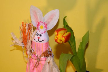 Dekoratif Paskalya tavşanı, lale arka planda, yakın görüş, mutlu Paskalya konsepti. 