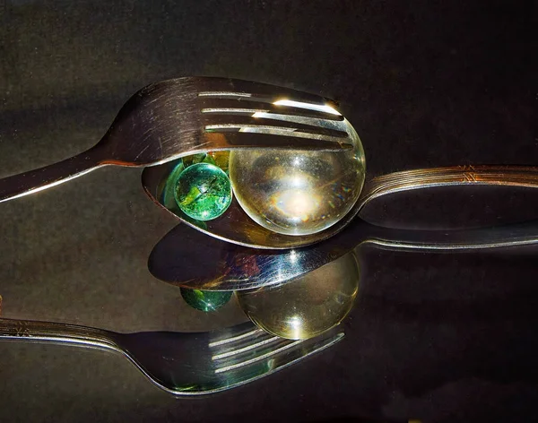 テーブルの上にカラフルなガラス玉でフォークとスプーン — ストック写真