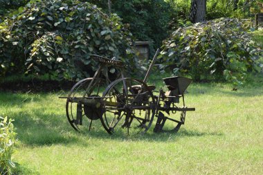 Bahçedeki yeşil çimlerde eski metal saban manzarası
