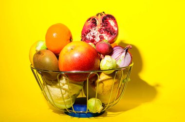 Olgun egzotik meyve ve sebze yığını demir kasede parlak arka planda, sağlıklı besin konsepti 