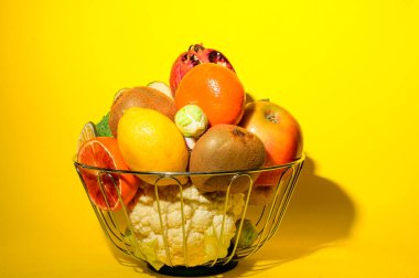 Olgun egzotik meyve ve sebze yığını demir kasede parlak arka planda, sağlıklı besin konsepti 