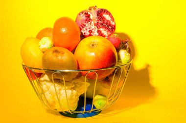 Olgun egzotik meyve ve sebze yığını demir kasede parlak arka planda, sağlıklı besin konsepti 