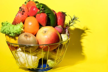 Olgun egzotik meyve ve sebze yığını demir kasede parlak arka planda, sağlıklı besin konsepti 