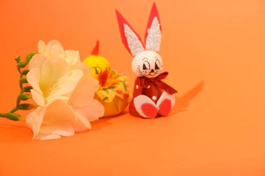 Dekoratif Paskalya tavşanlı güzel çiçekler ve parlak arka planda tavuk, bahar konsepti, yakın görüş   