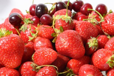 Taze ve sulu çilek ve kiraz yığını. 