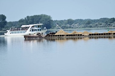 Nehirde hareket eden kumla dolu bir mavna 