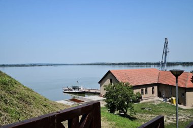 Güneşli bir günde nehrin kıyısına inşa edilen resimsel manzara