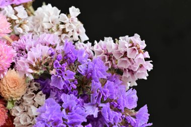 Siyah arka planda narin çiçekleri olan güzel çiçek buketini kapat.       