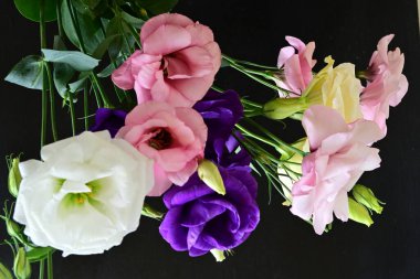 close up eustoma and rose flowers on black background 