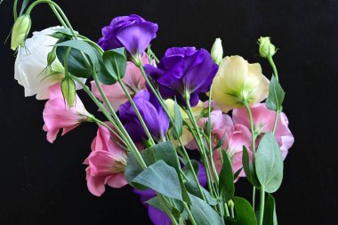 close up eustoma and rose flowers on black background 