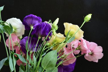 close up eustoma and rose flowers on black background 